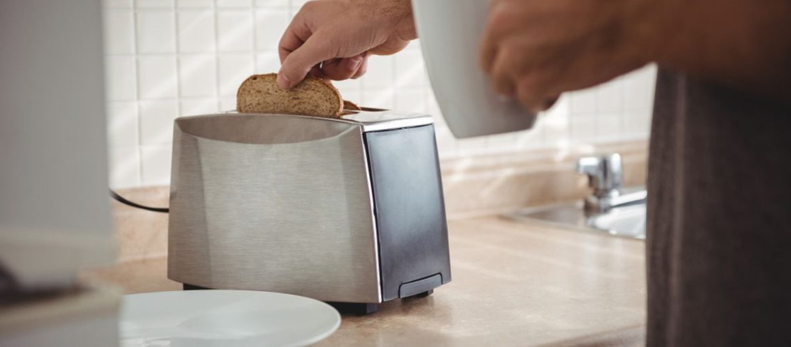 man toasting bread in the toaster